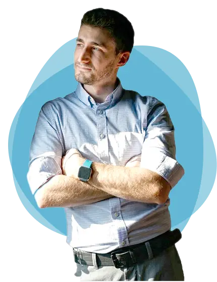 Josiah Partin stands with arms folded and blue circles behind him.
